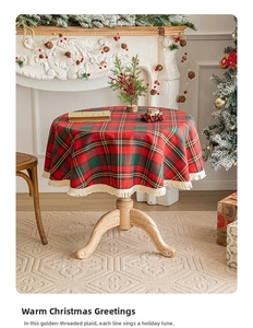 Close-up of red and green Christmas plaid tablecloth with gold thread and fringe detail