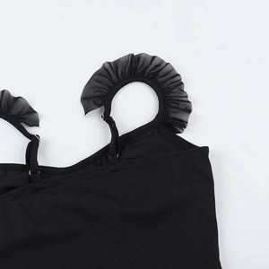 Dettaglio della spallina regolabile e dei volant in rete sul top a corsetto nero