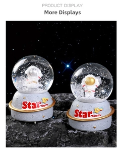 Close-up of Star Tours astronaut snow globes with star rings and moon surface base