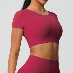 Vue latérale d'une femme en haut de yoga rouge rose ajusté et legging taille haute
