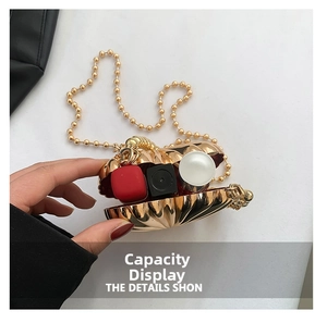 Detailed view of the shell-shaped evening bag interior holding three lipsticks