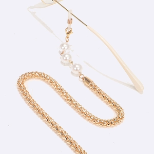 Detail of gold braided eyewear chain with white pearls and silicone anti-slip loops