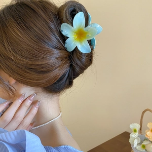 Detailed view of a blue flower-shaped hair claw clip made of acrylic on model hair