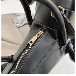 Close-up of black leather bag with gold metal zipper and smooth stitching detail