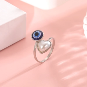 Detail of evil eye ring with blue bead and heart pearl on adjustable silver band