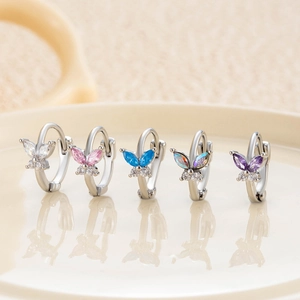 Copper butterfly hoop earrings set with colorful zircon stones on reflective plate