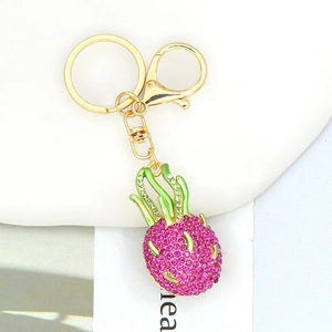 Detail of pineapple keychain with sparkling pink rhinestones and green enamel leaves
