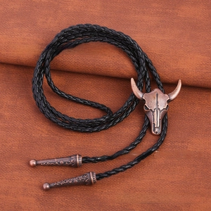 Detail of vintage bull skull bolo tie with antique bronze pendant and black braided cord