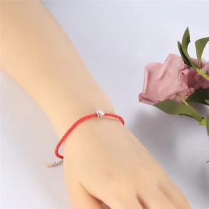 Close-up of red braided rope bracelet with a single sparkling cubic zirconia stone