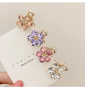 Detailed view of four mini floral hair claws with colorful crystals on a display card