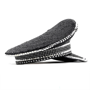 Detail of black sequined military hat with silver pyramid studs and rhinestone accents