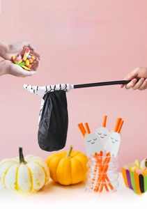 Halloween trick or treat bag featuring a spooky skull hand design and retractable pole