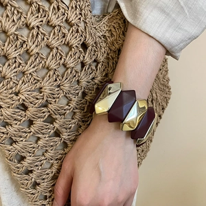 Chic burgundy and gold moon patchwork bracelet worn on a wrist with linen outfit