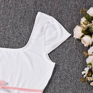 Detail of white cotton fabric featuring a delicate pink ribbon bow decoration