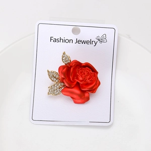 Detail of red enamel rose brooch with gold leaves and sparkling crystal accents