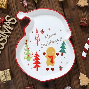 Festive ceramic Christmas plate with Santa design and Merry Christmas text on wooden background