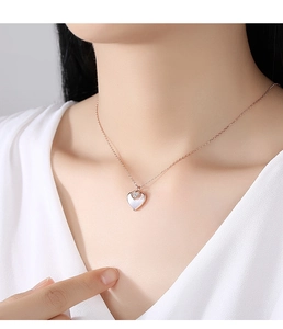 Nahaufnahme der roségoldenen Doppelherz-Halskette mit Muschel-Inlay und Pavé-Diamanten