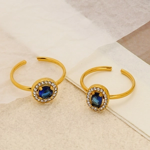 Detailed macro shot of gold-plated rings with deep blue gemstones and zircon accents