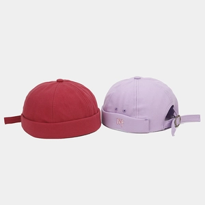 Detalle de gorros docker con hebillas metálicas ajustables y bordado en tela de algodón
