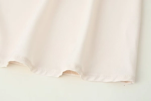 Vue détaillée de la couture d'ourlet précise d'une robe chemise sans manches beige
