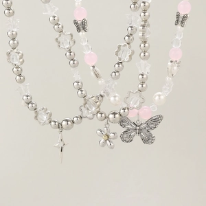 Detail of Y2K beaded necklaces with silver butterfly, star, and flower charms