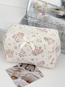 Detail der floralen Kosmetiktasche mit Satinschleife, Perlenanhänger und Reißverschluss