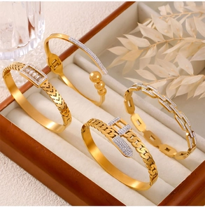 Close-up of gold titanium steel chain bracelets with sparkling zircon inlay on a tray