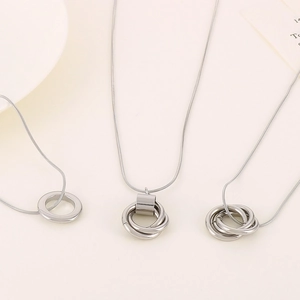 Three minimalist silver stainless steel necklaces with geometric ring pendants on snake chain