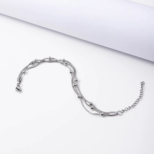 Detailed shot of multi-layer silver snake chain bracelet with metallic beads on white background