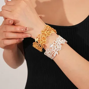 Moderne goldene und silberne offene Armreifen mit ausgestanztem Blumenmuster Retro