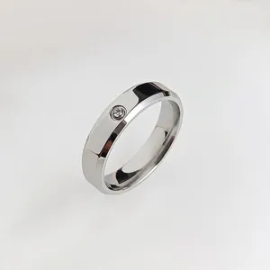 Polished stainless steel band ring featuring a single set round cubic zirconia stone
