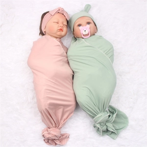Soft newborn swaddle set with headband and hat in lotus pink and mint green tones