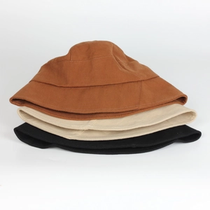 Three bucket hats in caramel, beige, and black colors stacked on a plain white background