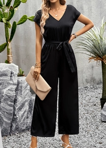 Detail of elegant black V-neck jumpsuit with a matching waist tie and wide-leg trousers