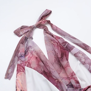 Gros plan du col licou et de l'imprimé marbré sur cette robe d'été élégante et raffinée