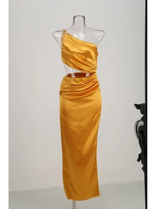 Detail of gold satin one-shoulder maxi dress featuring waist cutout and ruching