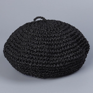 Close-up of black handmade crochet straw beret showing detailed woven texture and top loop