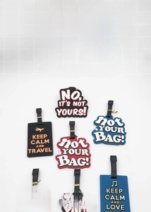 Close-up of colorful PVC luggage tags featuring Keep Calm and Travel embossed slogans
