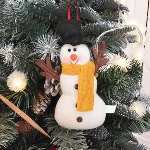 Plush snowman Christmas tree ornament with yellow scarf hanging on a festive tree branch