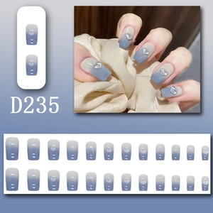Detailed view of D235 blue gradient press-on nails with silver 3D heart charms