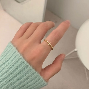 Close-up of a slim gold ring with sparkling star-shaped cubic zirconia on a finger