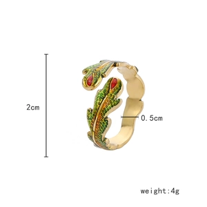 Macro shot of colorful enamel leaf ring with gold plating and red gem details