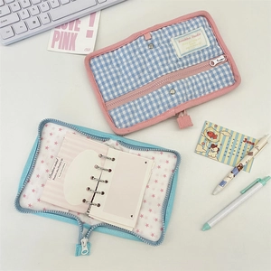 Detail of Korean style plaid storage pouch and mini 6-ring binder set on a white desk