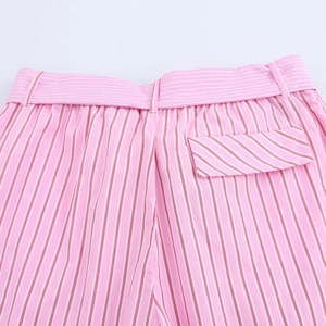 Close-up of pink striped trousers waist belt loops and back pocket detail on white back