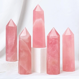 Set of five natural rose quartz hexagonal crystal pillars on white display pedestals