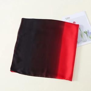Nahaufnahme eines Seidenschals mit sanftem Farbverlauf von Schwarz zu Rot auf Beige