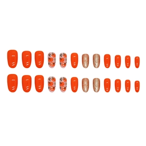 Faux ongles d'Halloween ovales mi-longs orange avec motifs citrouille et paillettes dorées