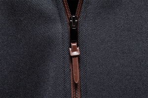 Close-up of premium metal zipper with brown leather puller on hoodie fabric