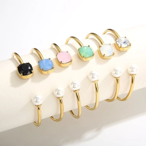 Golden C-shaped open bracelets with square colorful zircons and white pearls display