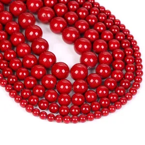 Macro shot of assorted red natural stone beads in circular arrangement with waxy luster